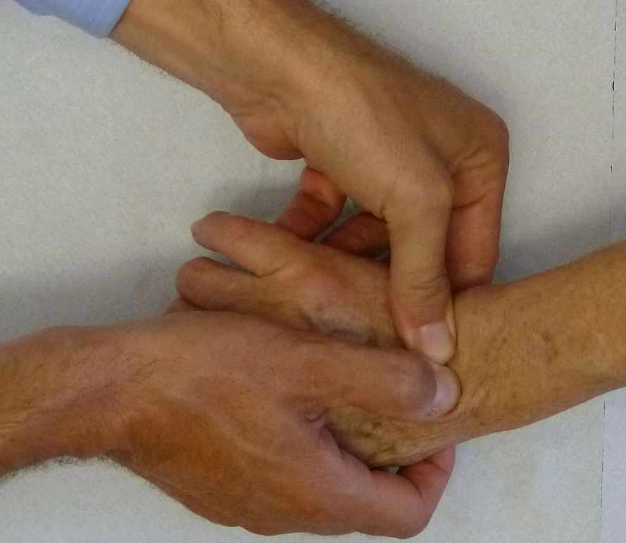 Paolo Leone valuta il polso tenendo la mano del paziente